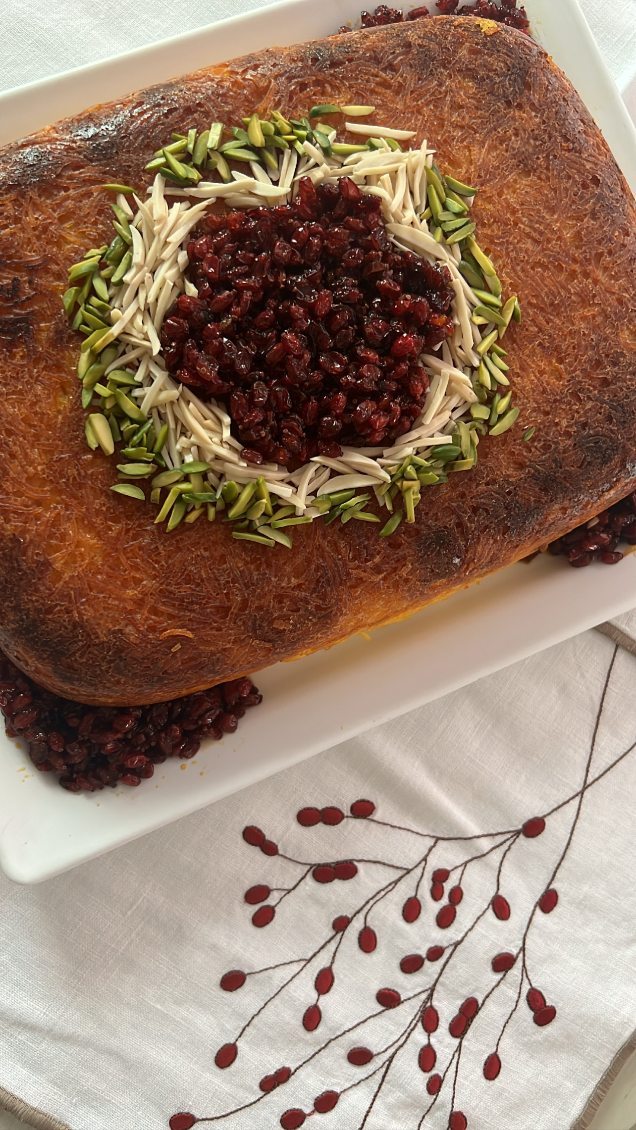 Homemade saffron chicken tahchin topped with barberries and nuts